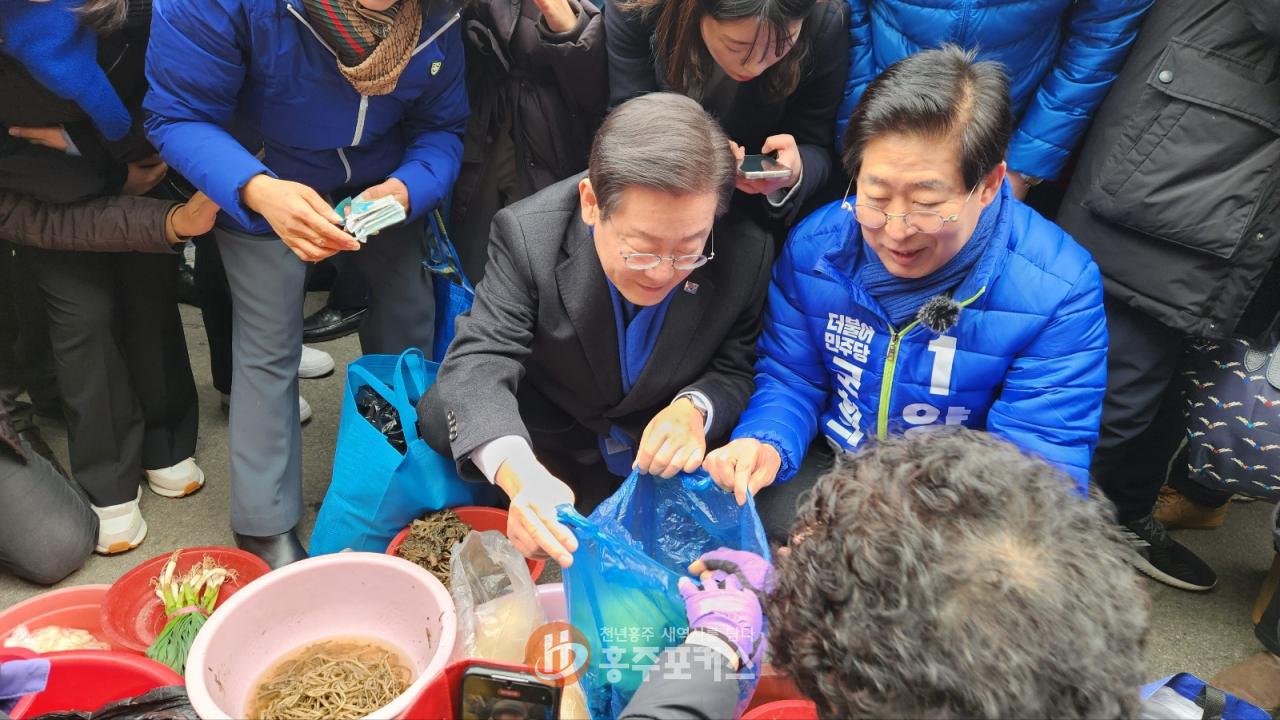 더불어민주당 이재명 대표가 11일, 홍성전통시장을 방문해 양승조 후보와 함께 야채를 구입하고 있다.